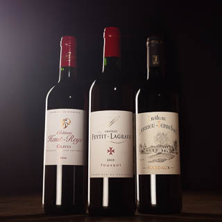Trois bouteilles de vin vue de face photographiées grâce à des éclairages de studio professionnels