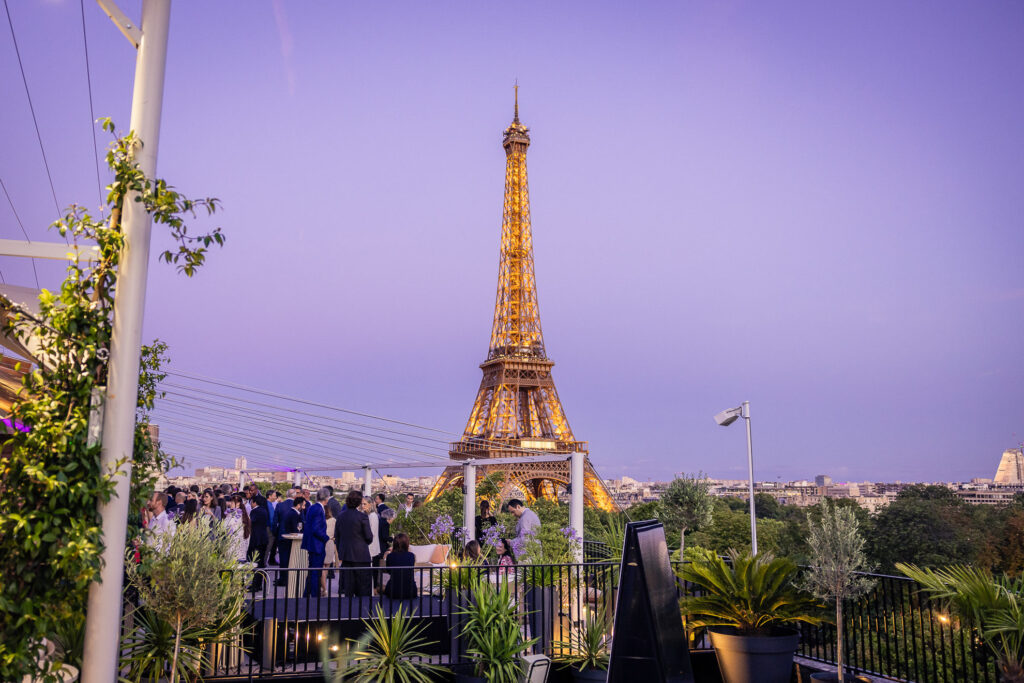 Cocktail de networking en soirée sur un rooftop avec vue sur la Tour Eiffel
